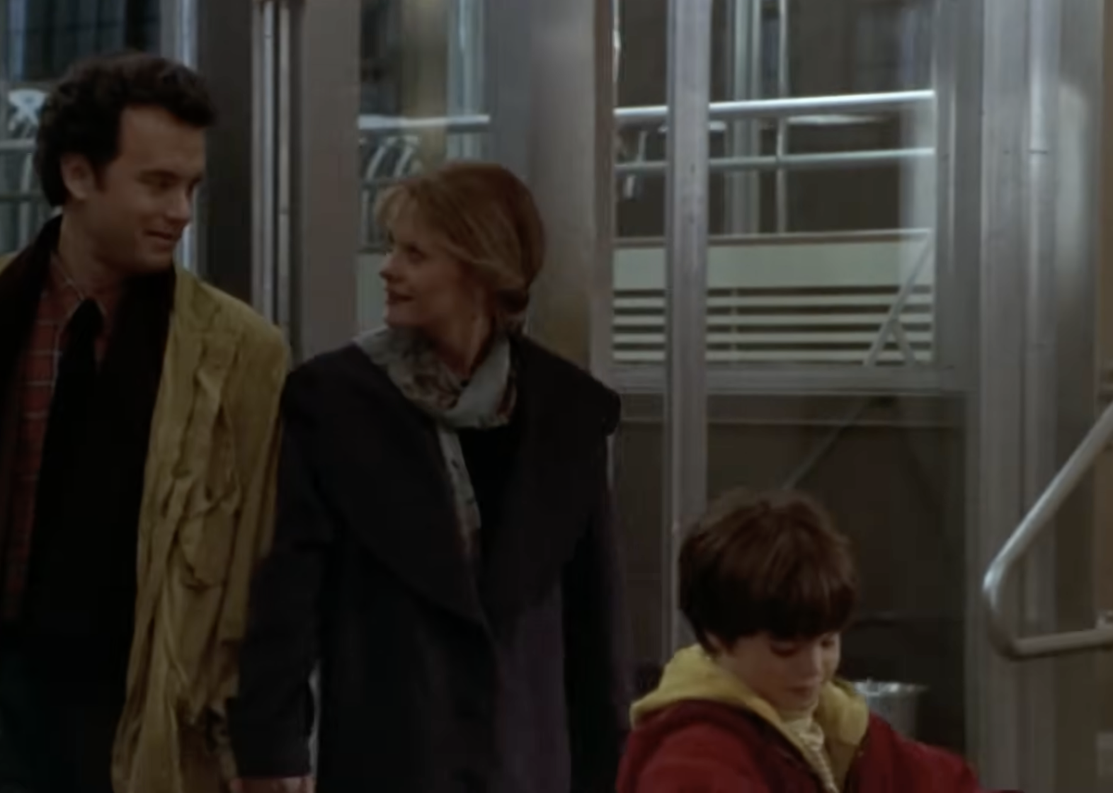 A young boy walks alongside two adults in a memorable scene from Sleepless in Seattle, capturing the warmth and family connection at the heart of the beloved romantic comedy. | Source: Scene City / YouTube.