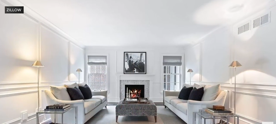 The “Home Alone” fireplace has been reimagined into a chic, modern focal point framed by crisp white walls and minimalist décor. Twin sofas and metallic accents create a balanced, elegant symmetry. The space glows with warmth and sophistication, blending contemporary style with timeless comfort. | Source: YouTube/CBSChicago