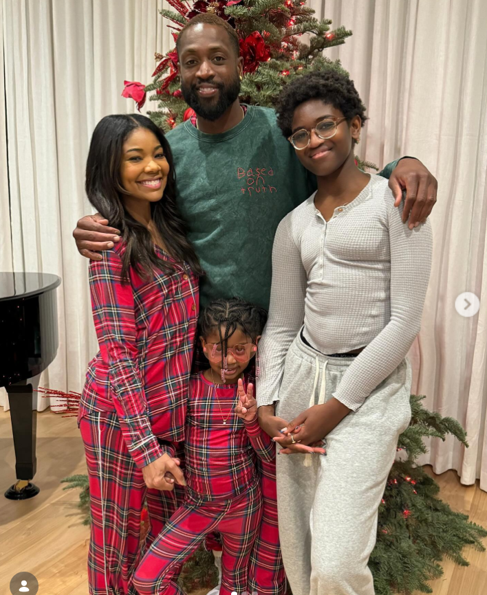 Another holiday-themed family photo captures Gabrielle and Dwyane standing with their children in front of a Christmas tree. | Source: Instagram/gabunion