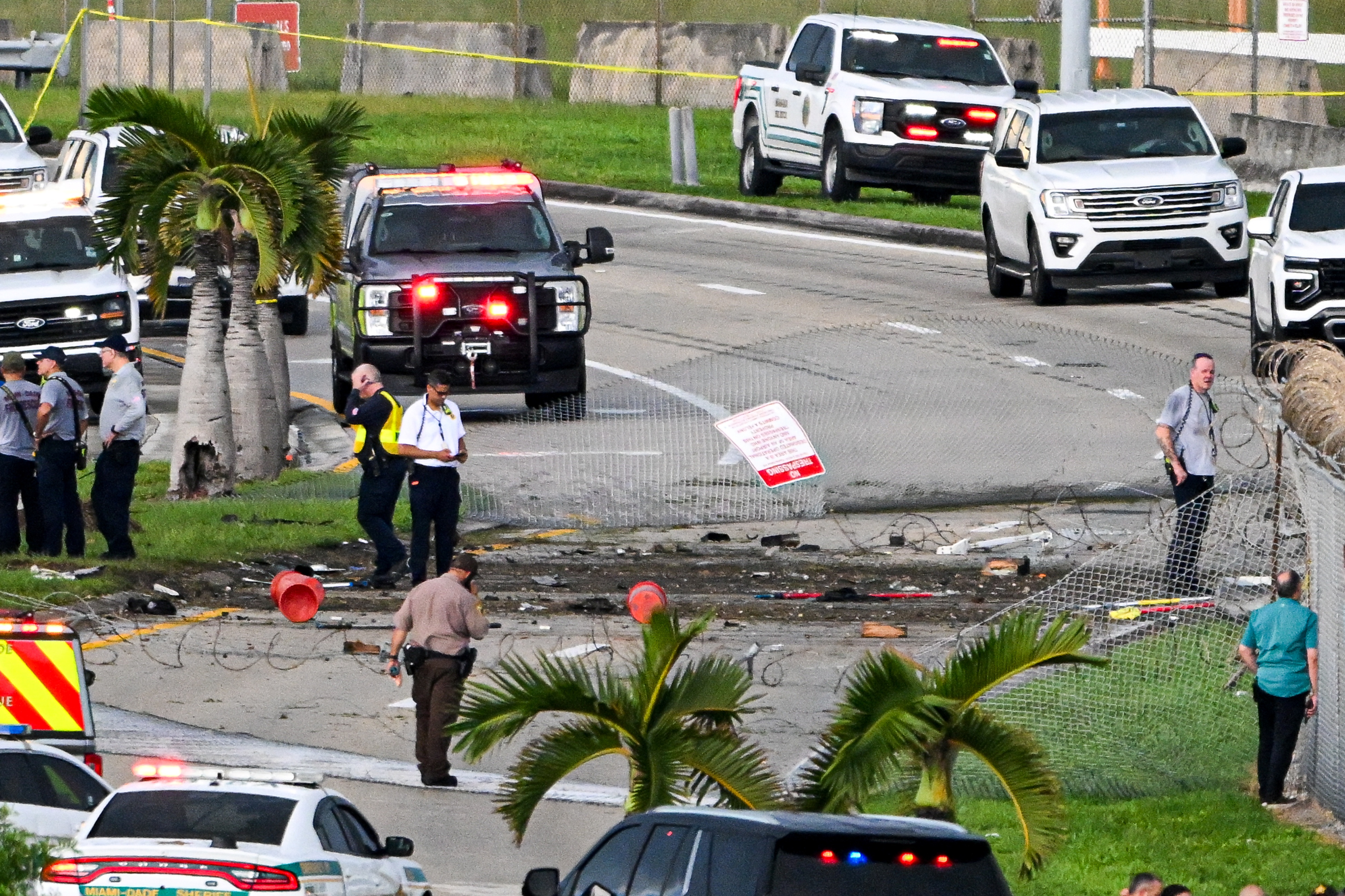 Investigators examine debris and damage along the aircraft's path beyond the airport grounds. Federal investigators have not yet determined why Flight 7598 was unable to stop after landing. | Source: Getty Images