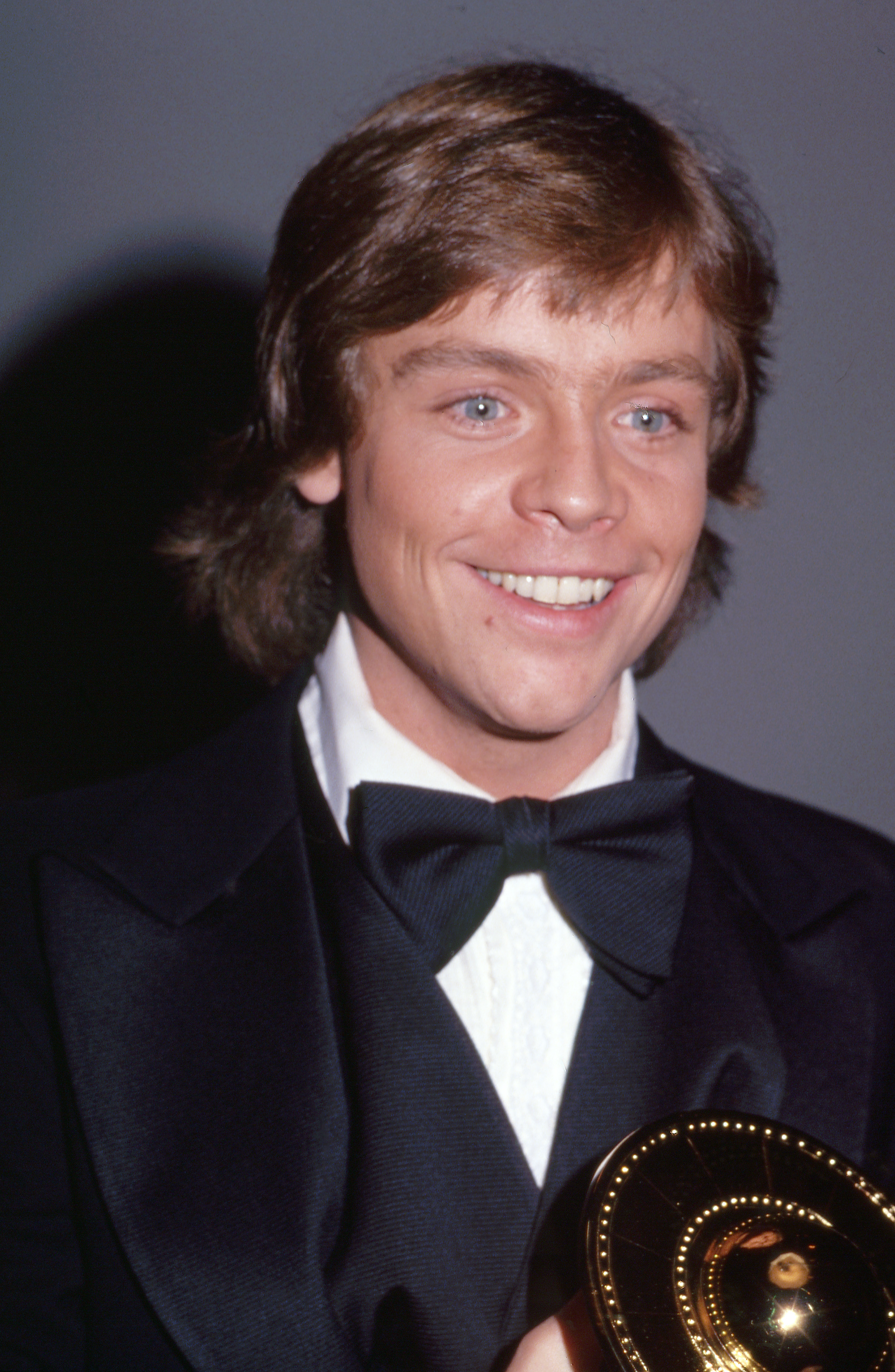 Mark Hamill attended the Saturn Awards at the Coconut Grove in California on January 21, 1978, one year after the car crash that fractured his nose and left cheekbone. Wearing a black tuxedo and bow tie, the "Star Wars" actor smiled while holding an award. The photograph offered a clear look at his appearance following reconstructive treatment. By then, Hamill had become widely recognized as Luke Skywalker after the film's blockbuster 1977 release.