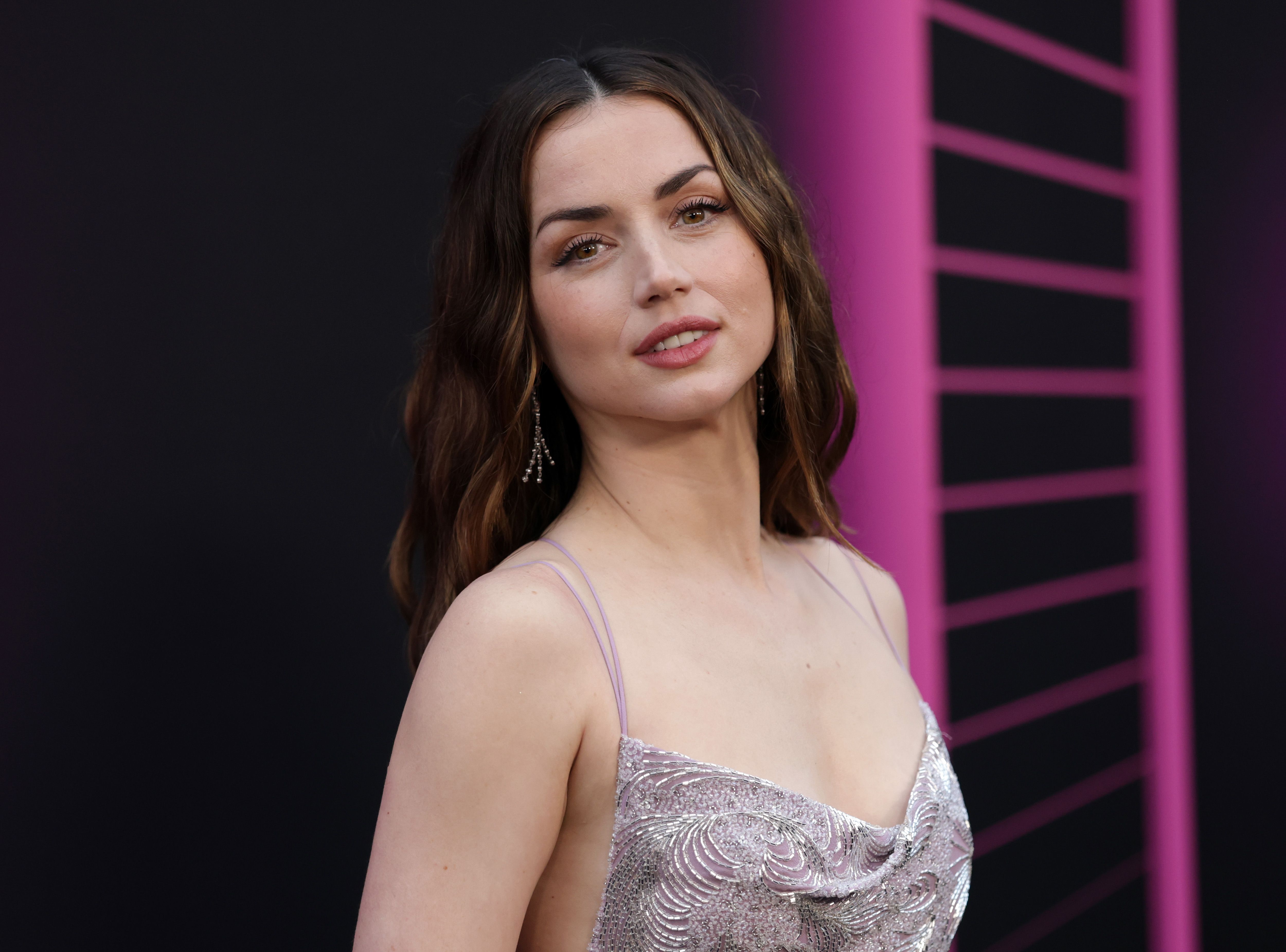 Ana de Armas glowed during a red carpet, in a shimmering lavender gown with thin spaghetti straps and intricate embellishments. With her softly waved hair, natural glam makeup, and dangling earrings, she exuded effortless elegance and Hollywood allure.