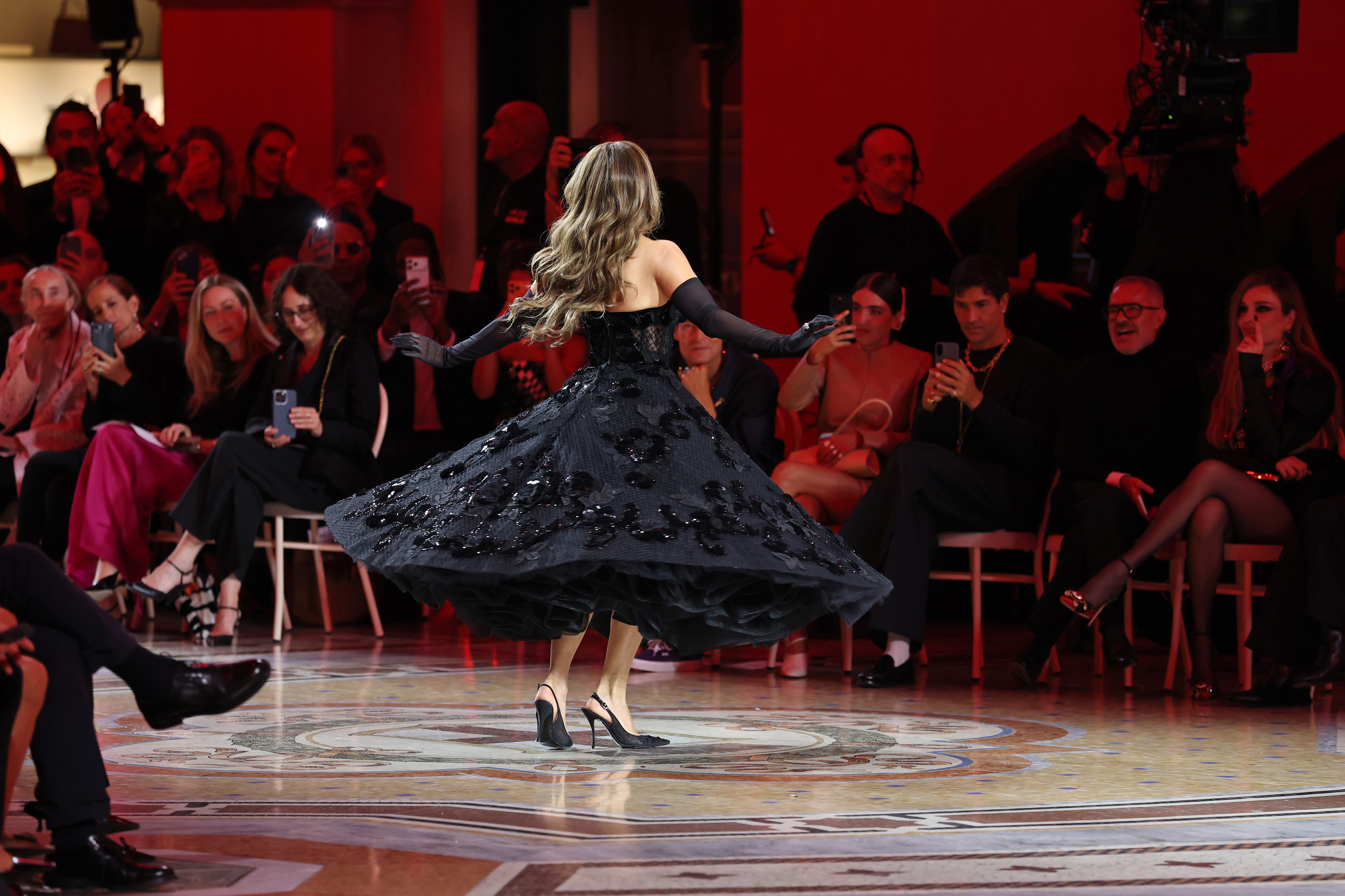 Lopez spins during the showcase, sending the voluminous skirt of her black gown sweeping through the air. | Source: Getty Images