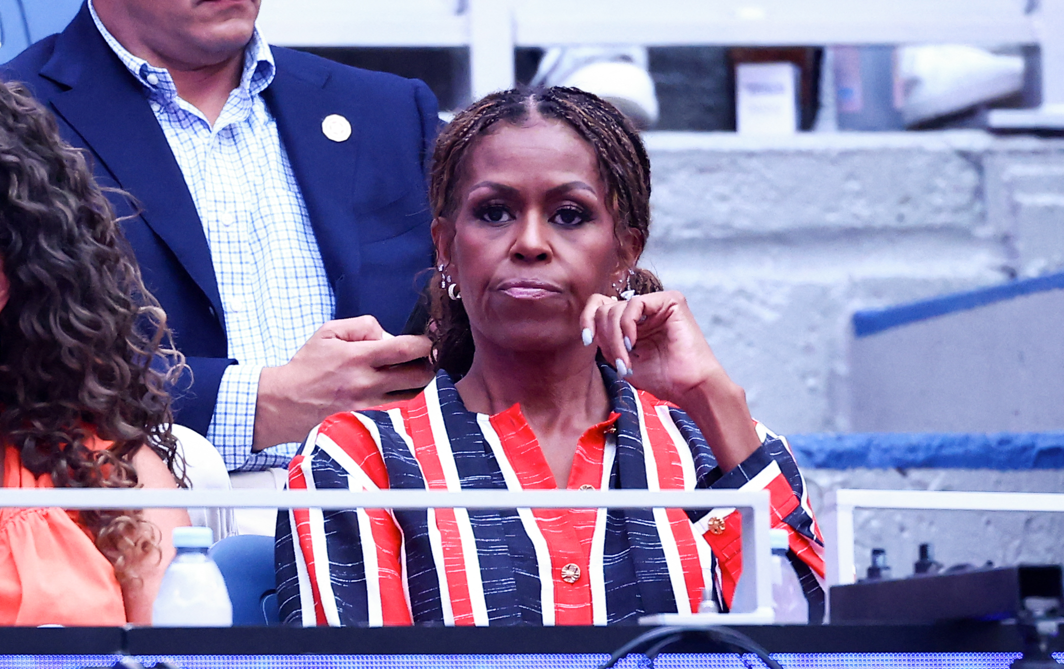The gold ear stack was not the only detail Michelle repeated across the look. Her jewelry also included multiple rings, while the dress itself was finished with gold buttons, tying the more playful piercings back into an otherwise polished Chanel outfit. | Source: Getty Images
