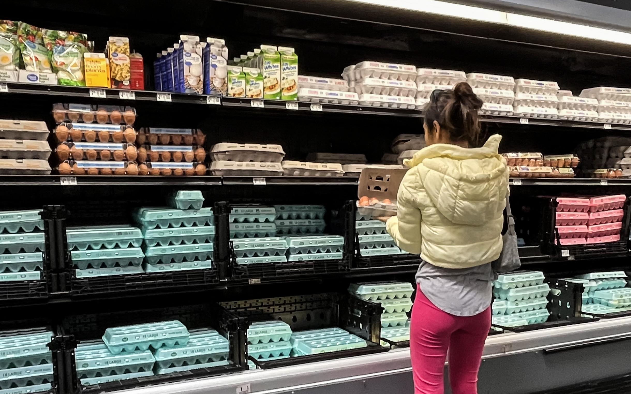 A shopper checks cartons of eggs on display as consumers are advised to review product codes and dates. | Source: Getty Images