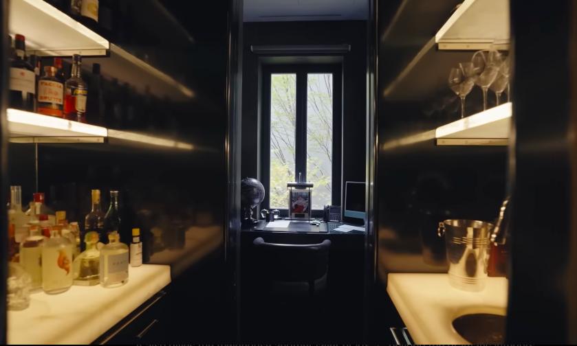 The hidden bar area brings a private-club feel to the top floor of the home. It is one of the most cinematic spaces in the townhouse, especially with its dark walls and warm backlighting. | Source: YouTube/Architectural Digest