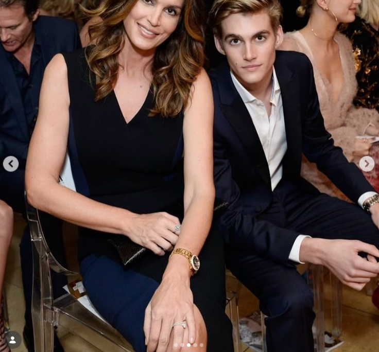 In a formal throwback memory revisited on February 20, 2024, Cindy Crawford posed in an elegant sleeveless navy-and-black dress alongside a dapper Presley Gerber dressed in a sharp dark suit and open-collared white shirt. | Source: Instagram/presleygerber
