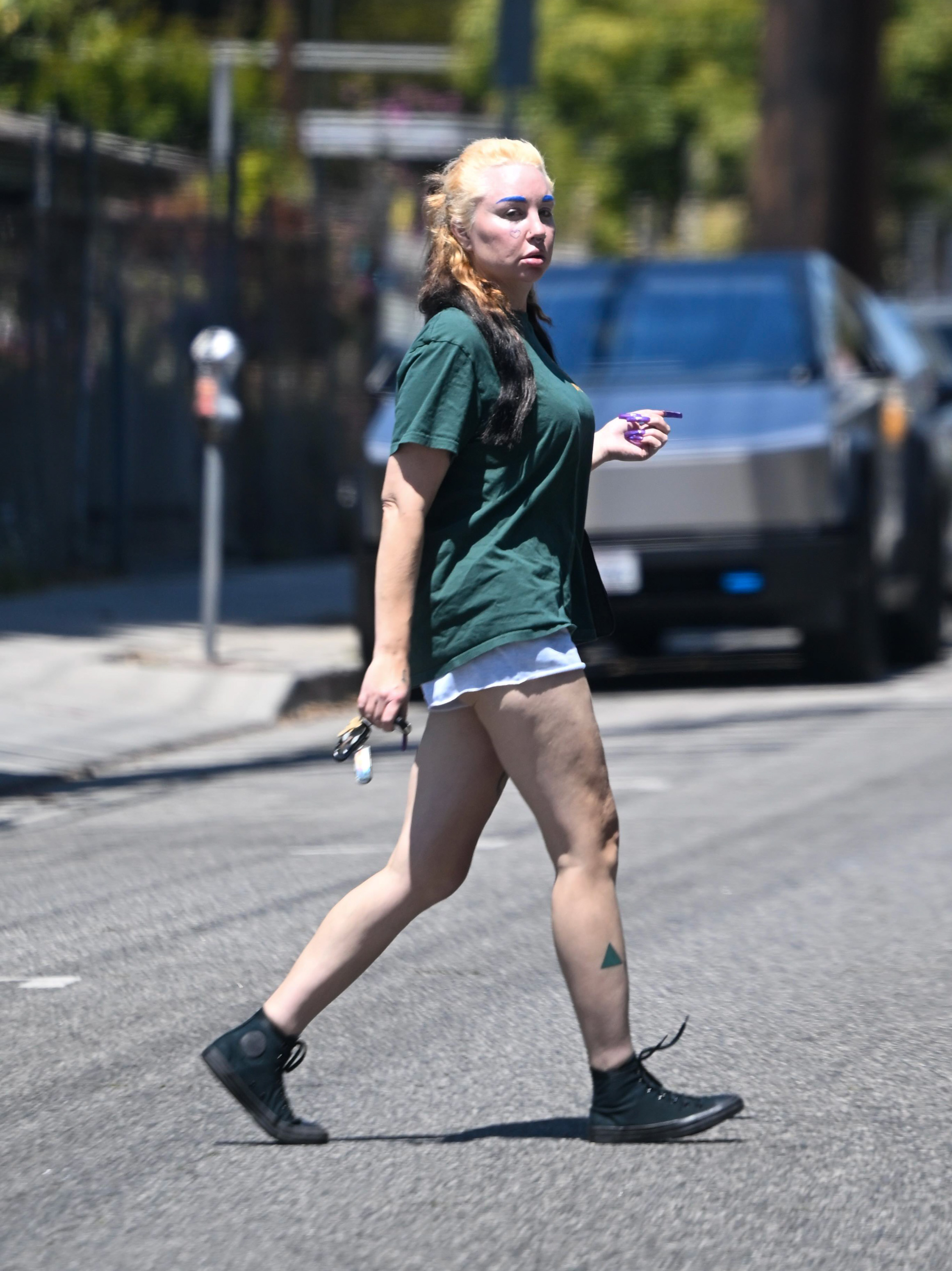 Another photo from the same appearance showed Bynes crossing a Los Angeles street in black high-top sneakers and rolled shorts, highlighting the contrast between her bold beauty choices and casual streetwear style.