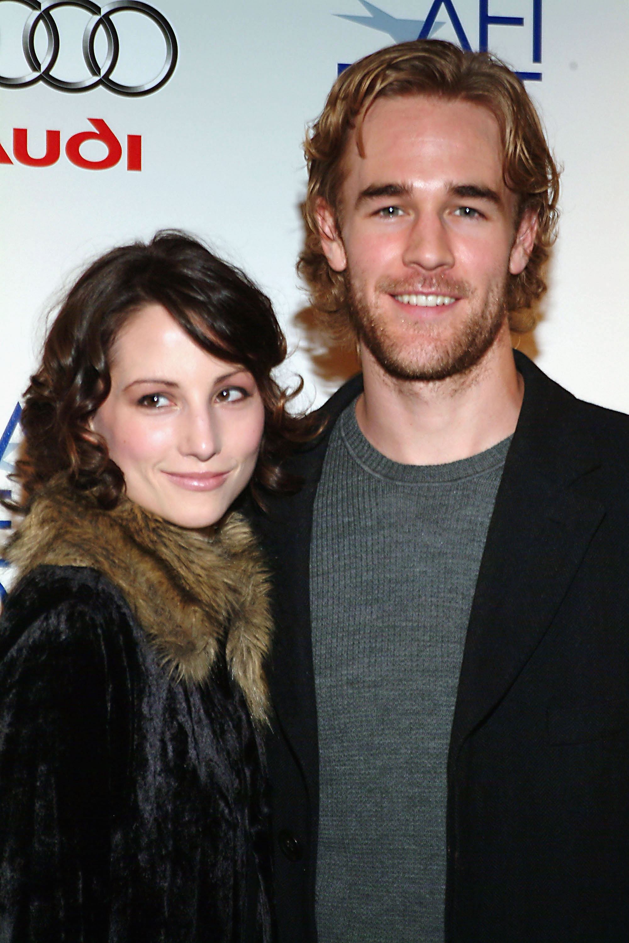 James Van Der Beek arrives at the AFI Fest with a relaxed smile in a sweater and blazer. Heather McComb stands beside him in a black fur-trimmed coat, her curls and serene smile adding elegance. Together, they exude calm sophistication at the RX premiere.