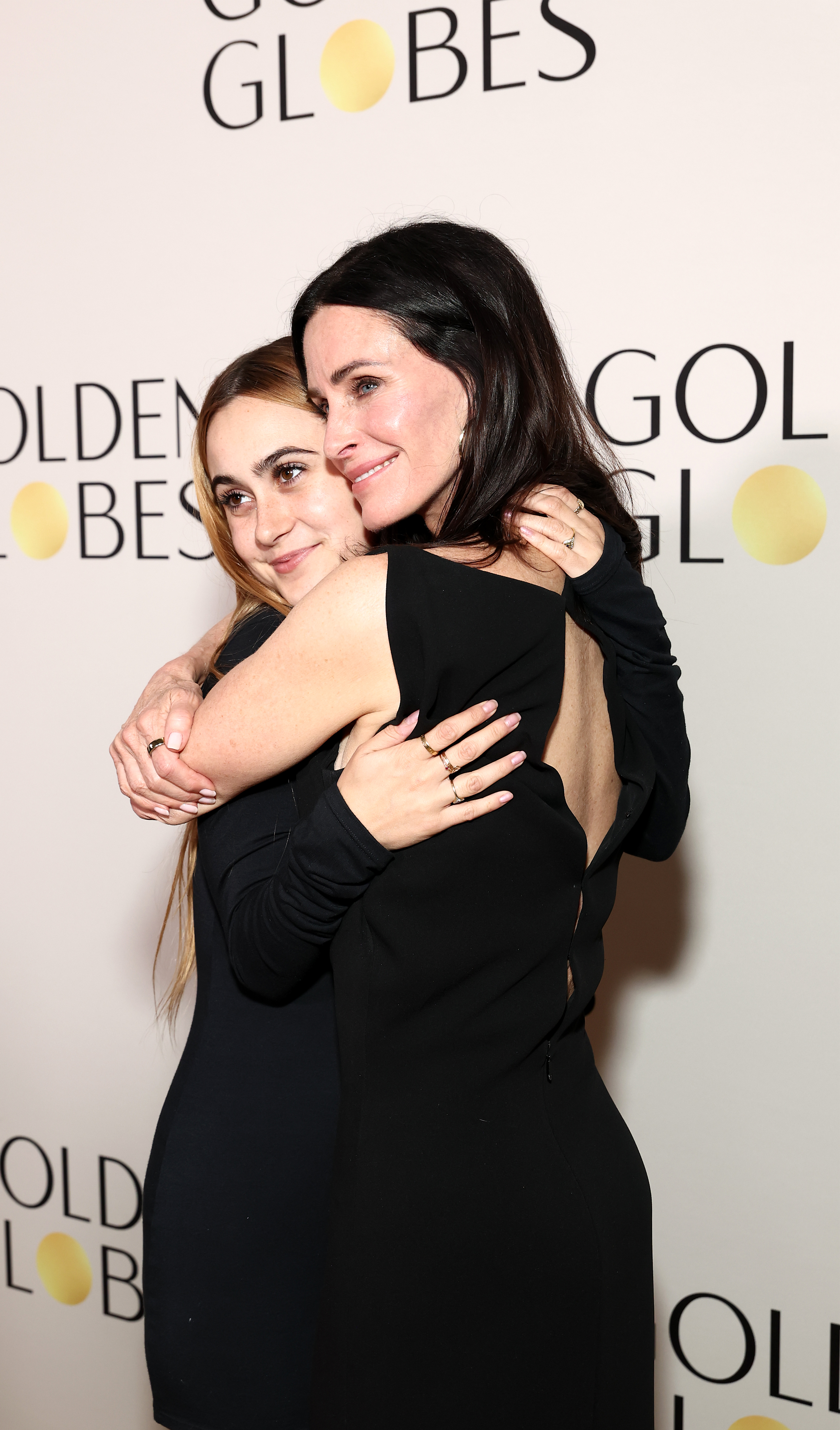 Courtney and Coco share a particularly affectionate embrace at the Road to the Golden Globes Kick-Off Party, with Coco wrapping her arms around her mother as they pose against the event backdrop. The intimate moment offers a glimpse of their close bond beyond the spotlight surrounding Evil Genius. | Source: Getty Images