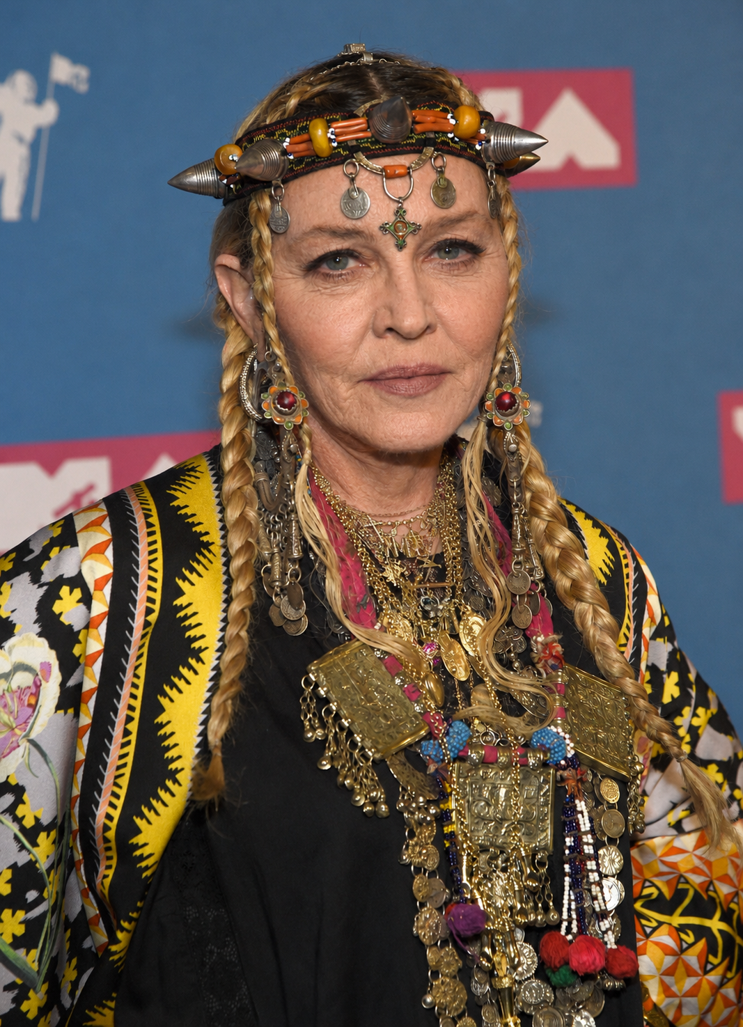 For the digital reimagining, Madonna's elaborate headpiece, braids, jewelry and patterned clothing are preserved as her facial appearance is transformed. | Source: Chat GPT