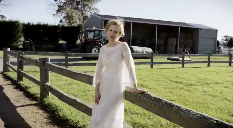 A working shed stocked with hay bales and farm equipment sits in the background as Nicole Kidman leans casually on the fence, capturing the property's functional side amid its pastoral beauty. From a video dated July 20, 2015. | Source: YouTube/Vogue